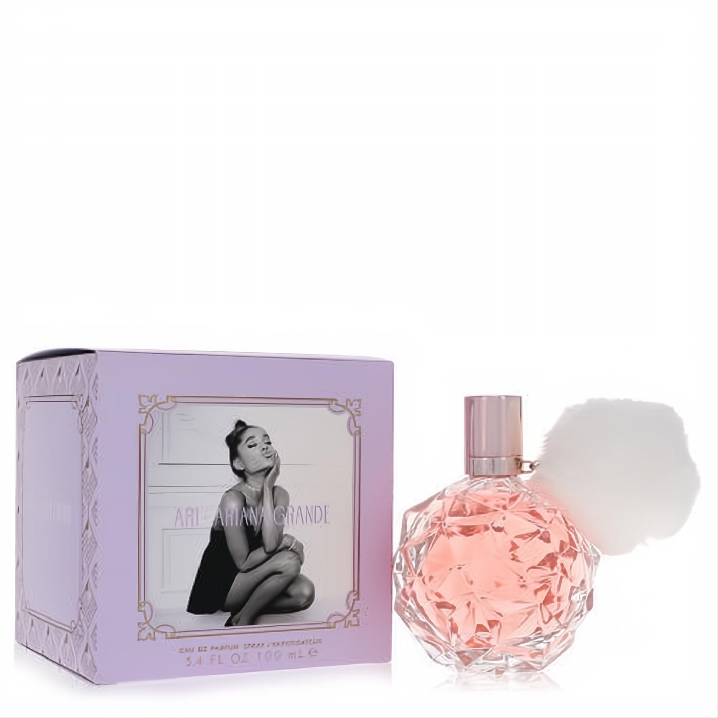 Ari by Ariana Grande 3.4 oz EDP. Elegant faceted pink bottle with a chic rose gold cap and playful white pom-pom, beside its lavender box.