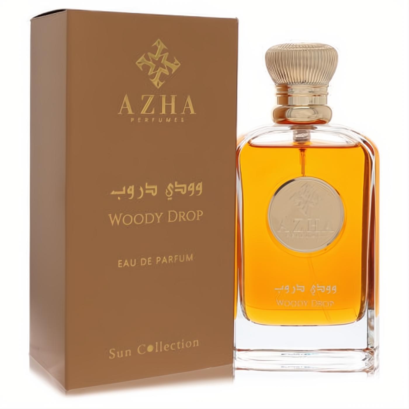 Elegant Azha Woody Drop EDP, clear glass bottle with rich golden fragrance and textured gold cap, beside its matching bronze box.