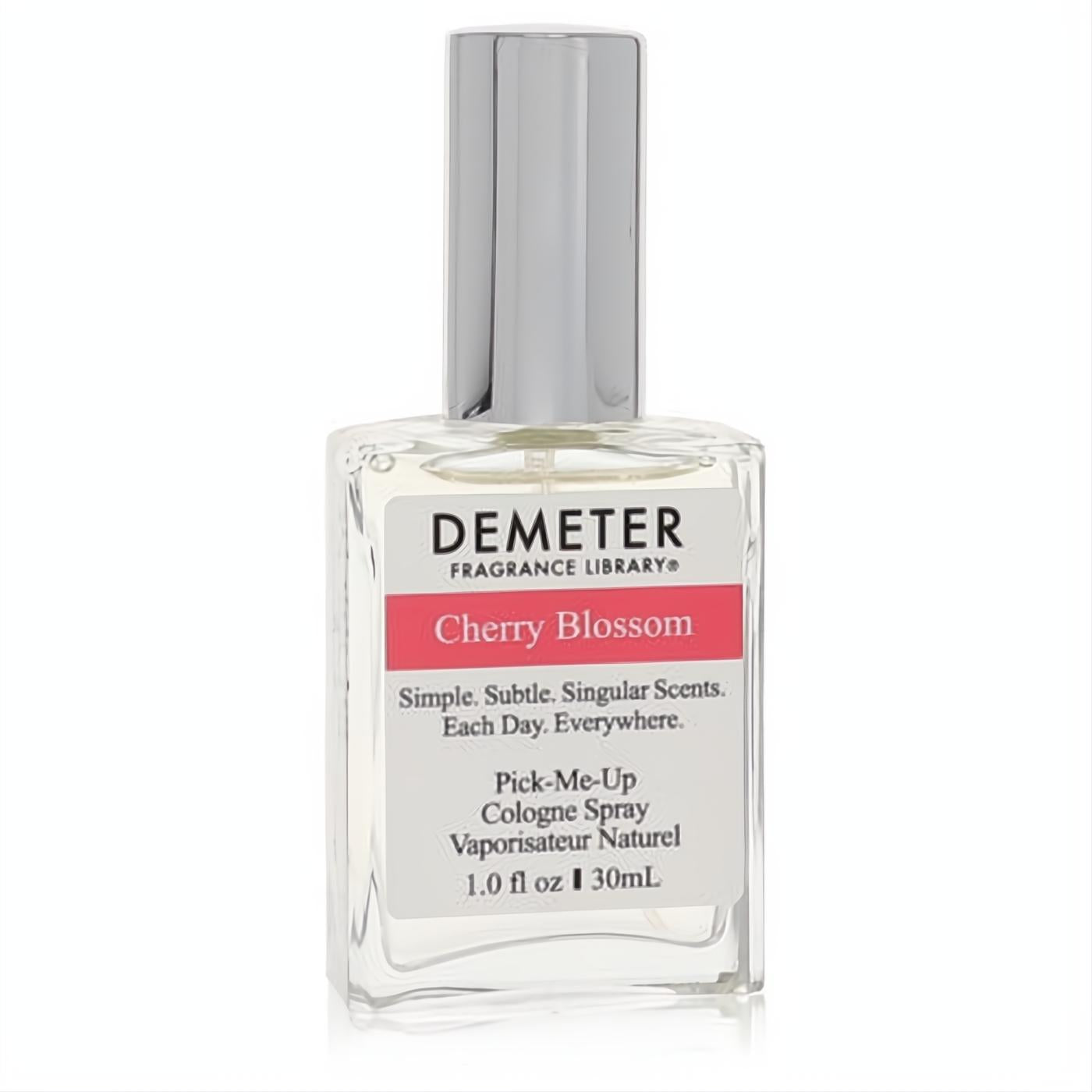Elegant Demeter Cherry Blossom 1 oz women's cologne spray. Clear glass bottle, sleek silver cap, and a white label with a vibrant pink 'Cherry Blossom' band.