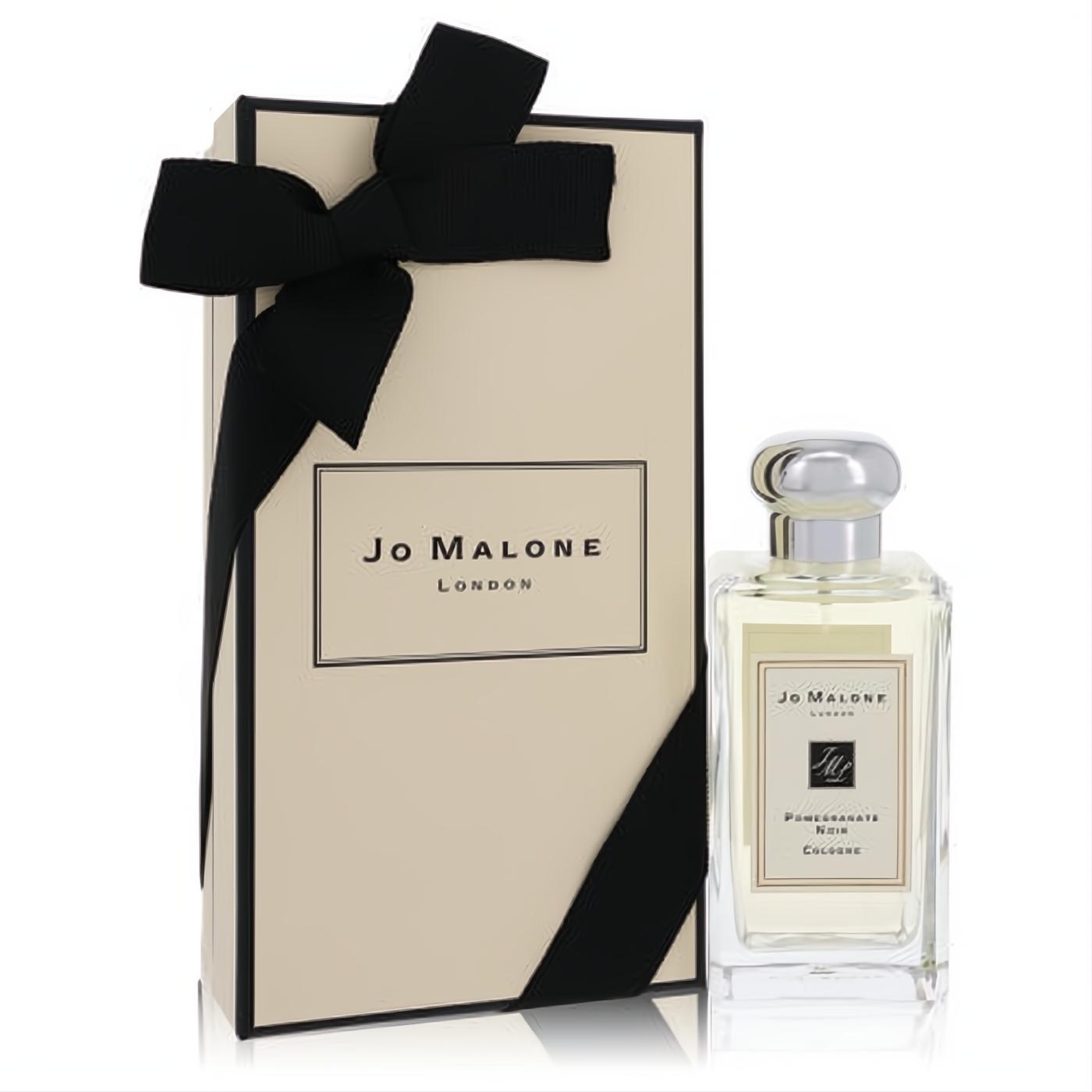 Sophisticated Jo Malone Pomegranate Noir cologne in a clear glass bottle with silver cap, beside its iconic cream gift box tied with a black ribbon.