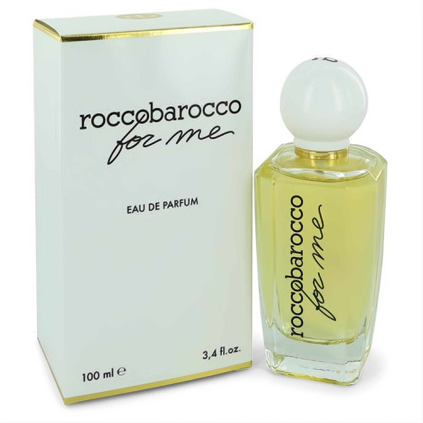 Elegant Roccobarocco For Me 3.4 oz Eau De Parfum. Clear glass bottle with light yellow liquid, white spherical cap, and matching white box with gold trim.
