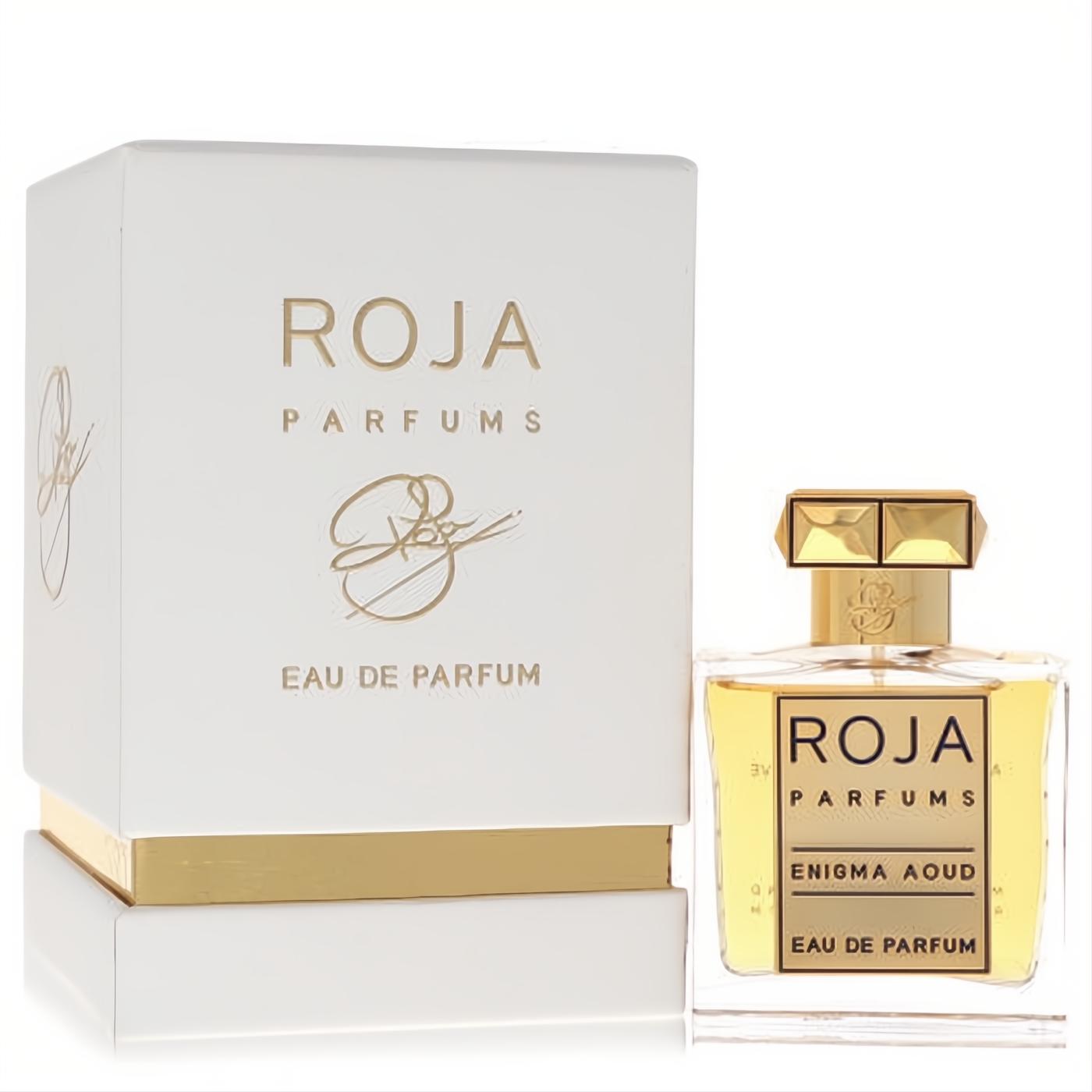 Discover Roja Enigma Aoud Eau De Parfum. Clear glass bottle with faceted gold cap, rich amber liquid, and elegant white & gold box.