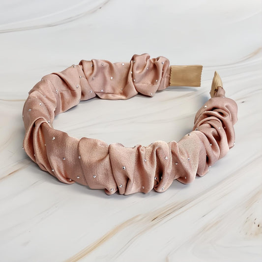 Elevate your look with this elegant blush pink scrunched satin headband, adorned with sparkling jewel dots.