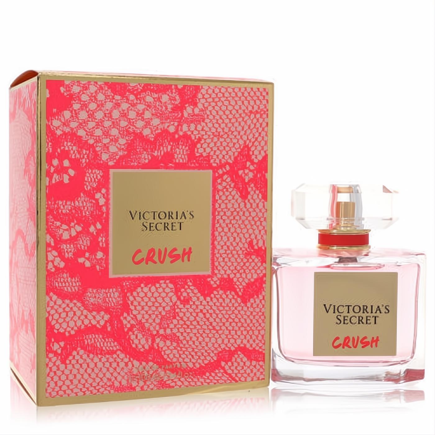 Victoria's Secret Crush Eau De Parfum spray. Clear glass bottle with light pink perfume, next to its vibrant pink lace and gold box.