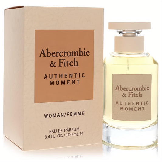 Abercrombie & Fitch Authentic Moment 3.4 oz EDP. Clear glass bottle with beige cap, elegant label, and matching cream box.