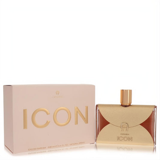 Aigner Icon 3.4 oz Eau de Parfum for women. Luxurious bottle with a distinctive gold metallic overlay, amber liquid, and elegant pink box.