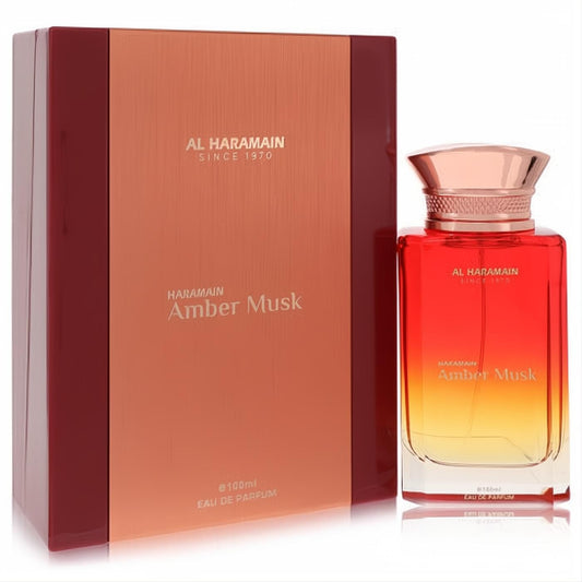 Al Haramain Amber Musk 3.3 oz unisex EDP in a stunning red-orange gradient glass bottle with a rose gold cap, next to its elegant box.