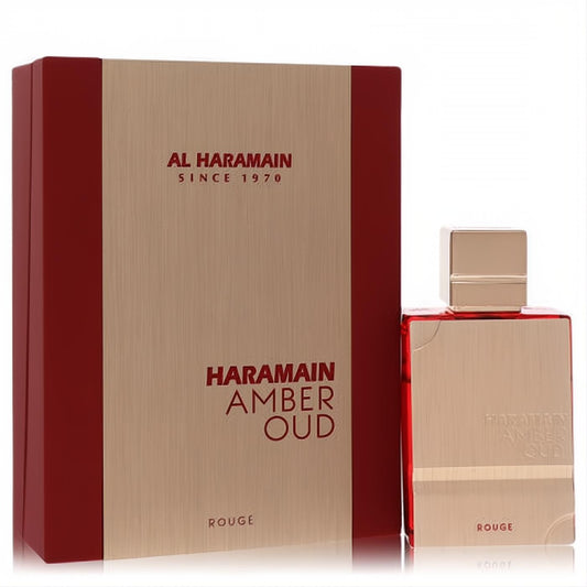 Luxurious Al Haramain Amber Oud Rouge 2 oz EDP. Sleek rose gold bottle with red liquid, alongside its elegant red and metallic gold box.