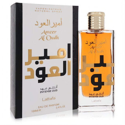 Unisex Ameer Al Oudh Intense Oud Lattafa 3.4 oz EDP. Amber liquid in a sleek glass bottle with gold cap, beside its elegant white & black box.