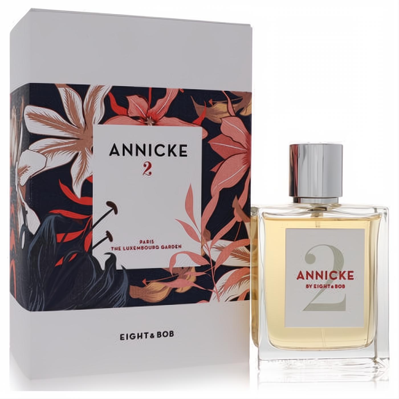 Annicke 2 Eau De Parfum in a clear glass bottle with silver cap, next to its elegant white box with vibrant floral art.