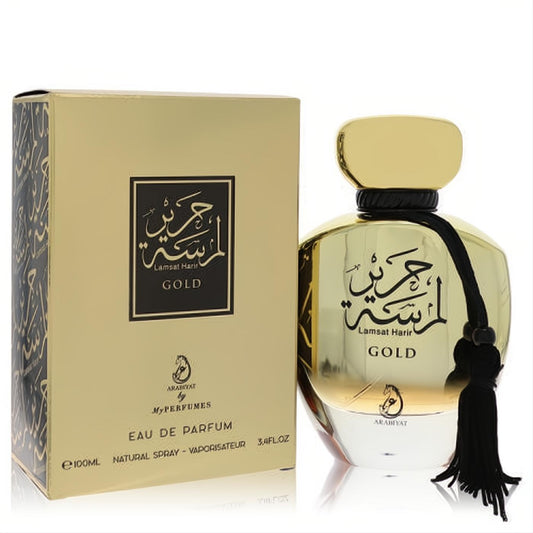 Luxurious Arabiyat Lamsat Harir Gold 3.4 oz EDP. Elegant metallic gold bottle, black tassel, and Arabic calligraphy.