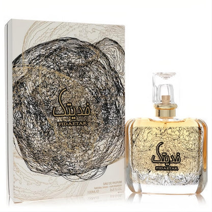 Ard Al Zaafaran Fidaetak unisex EDP 3.4 oz. Clear bottle with golden liquid, captivating black and gold swirl design, and matching box.