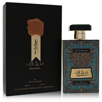 Ard Al Zaafaran Meethaq unisex perfume, 3.4 oz. Luxurious black bottle with ornate teal and gold pattern, beside its elegant black box.
