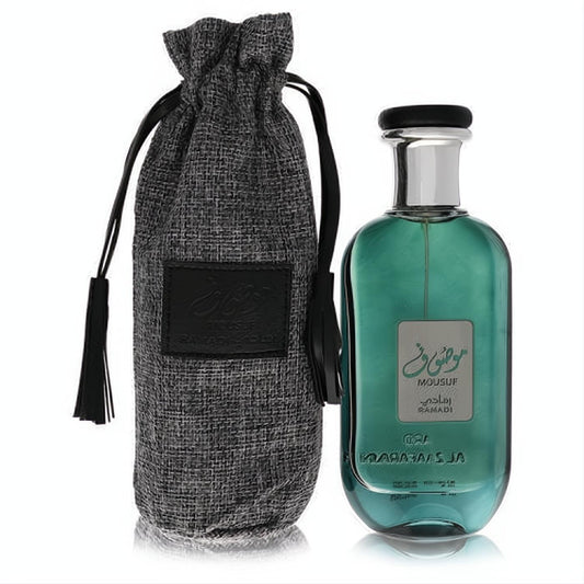 Elegant Ard Al Zaafaran Mousuf Ramadi 3.4 oz unisex perfume. Sleek teal glass bottle, silver cap, and a premium grey textured drawstring pouch.