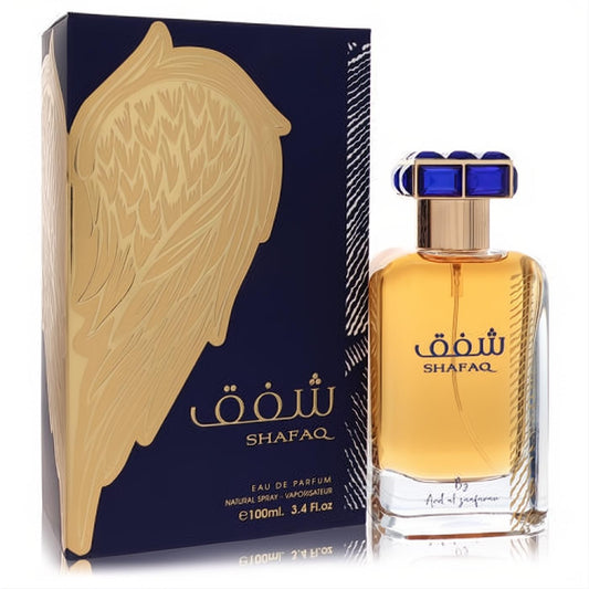 Ard Al Zaafaran Shafaq 3.4 oz EDP: Luxurious gold-amber fragrance in a clear bottle with a blue & gold cap, next to a dark blue box with a striking gold wing