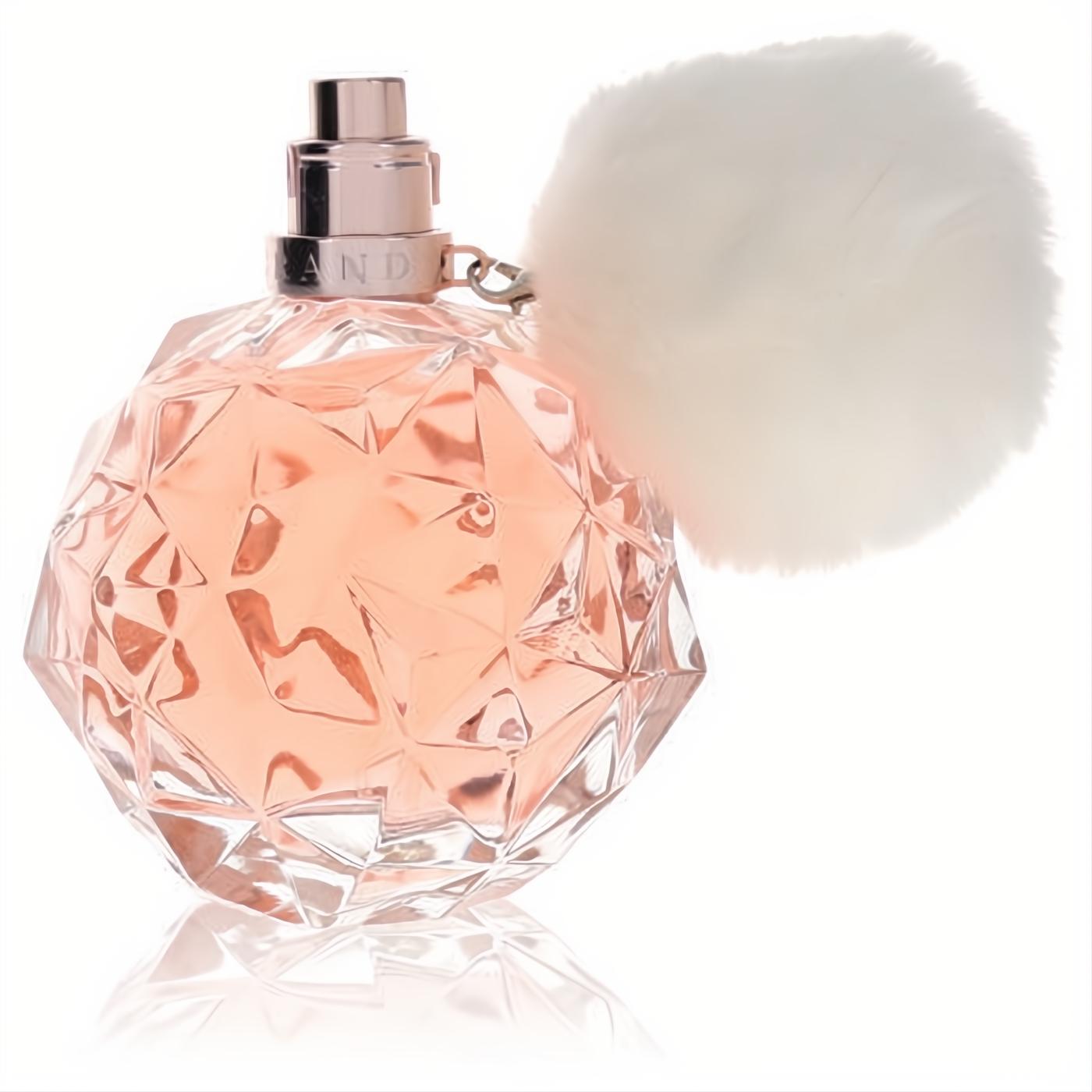 Ari by Ariana Grande Eau De Parfum: stunning faceted glass bottle, rose gold cap, light pink fragrance, and playful white pom-pom charm.