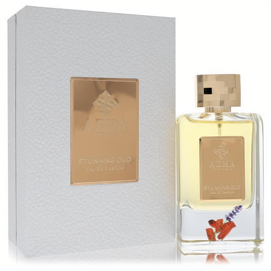 Elevate your scent with Azha Stunning Oud Eau De Parfum. Clear glass bottle, gold accents, and real lavender inside a white textured box.