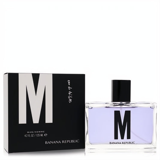 Banana Republic M Eau de Toilette 4.2 oz. Sleek clear glass bottle with lavender liquid, bold black M logo, and modern black/white box.