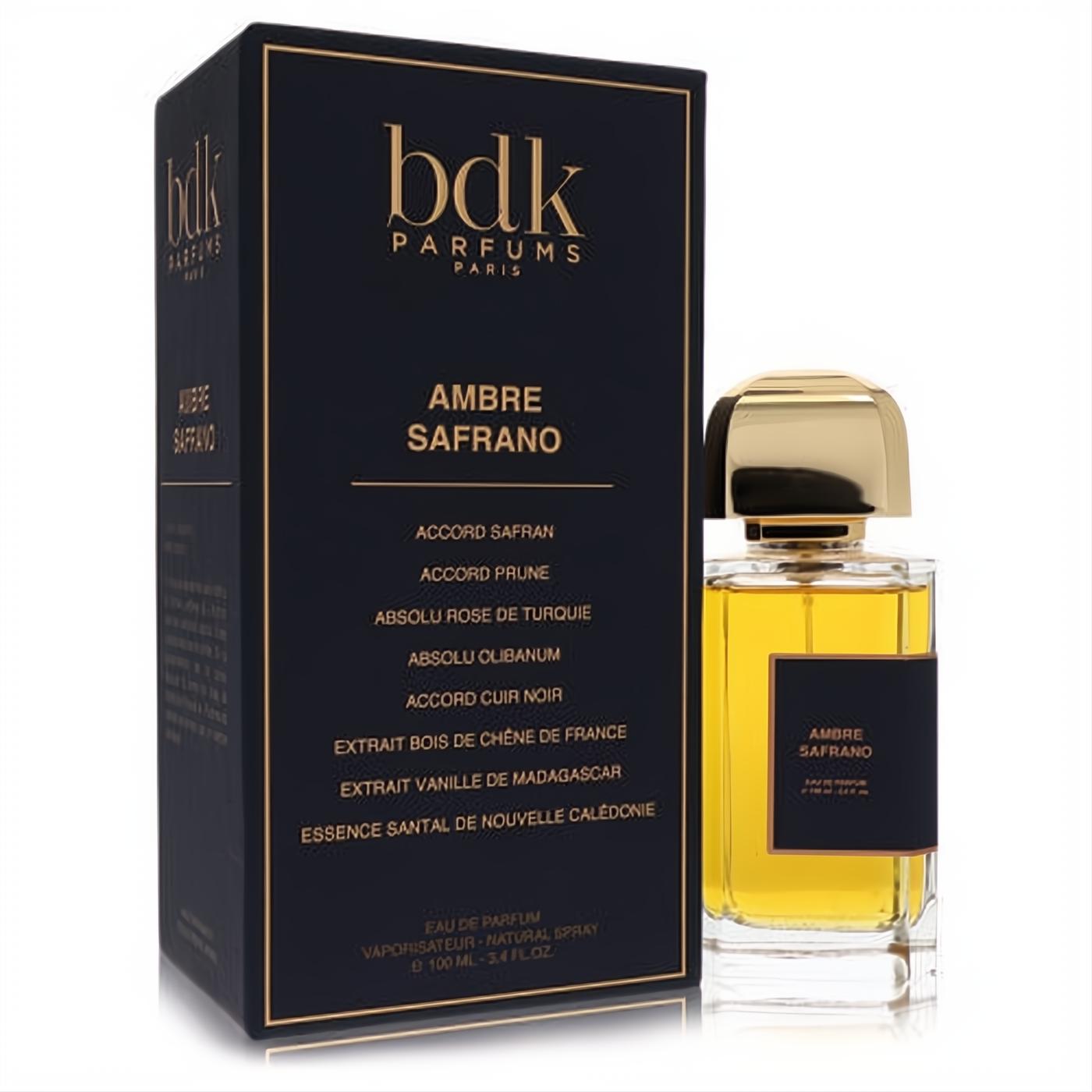 Luxurious Bdk Ambre Safrano 3.4 oz unisex EDP spray. Amber liquid in a clear bottle with a gold cap, beside its chic black and gold box.