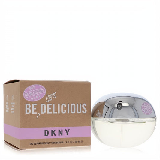 DKNY Be Delicious 3.4 oz Eau De Parfum spray. Iconic clear spherical bottle with a sleek silver cap, beside its brown and purple box.
