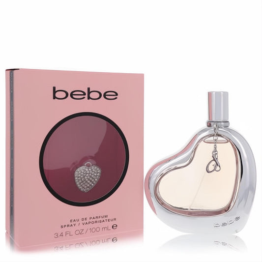 Bebe by Bebe 3.4 oz Eau de Parfum. Chic silver heart bottle with amber liquid and a sparkling pave charm, beside its pink box.