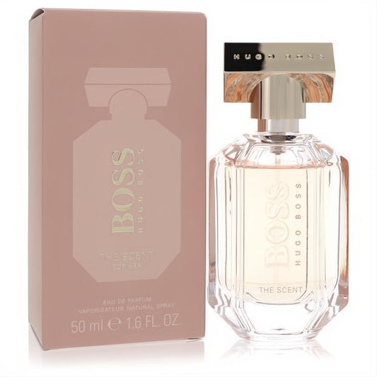 Boss The Scent for Her 1.6 oz Eau de Parfum. Modern faceted glass bottle with light peach liquid and a stylish dusty rose box.