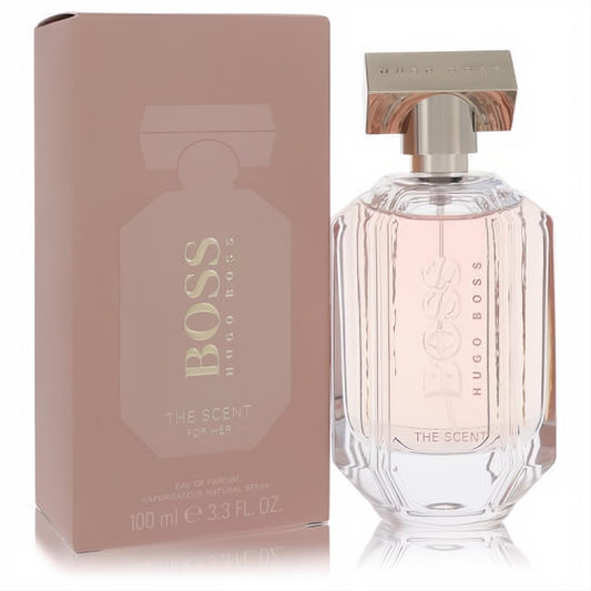 Boss The Scent for Her 3.3 oz Eau De Parfum. Elegant faceted glass bottle with pink fragrance, rose gold cap, and matching dusty rose box.