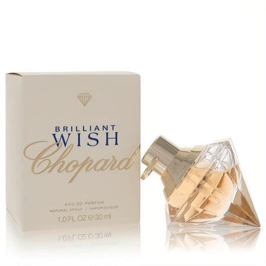 Discover Chopard Brilliant Wish 1 oz Eau De Parfum. Faceted diamond bottle with golden sprayer, next to its elegant cream box.