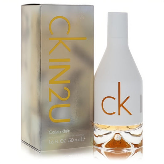 Iconic Calvin Klein CK IN2U 1.7 oz EDT for women. Sleek white bottle, amber liquid, and metallic box with bold yellow text.