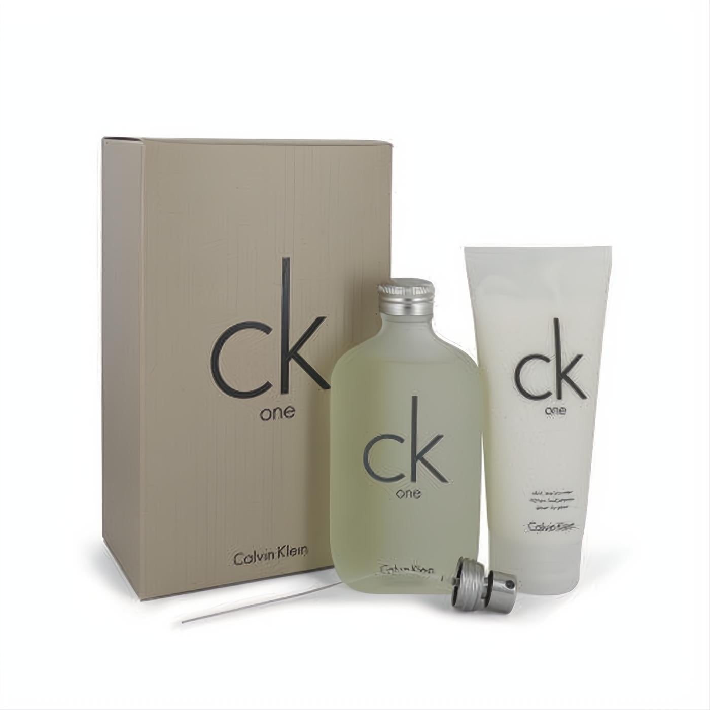 CK ONE Calvin Klein fragrance gift set: frosted glass EDT bottle, detached spray, white body moisturizer, and elegant beige box.