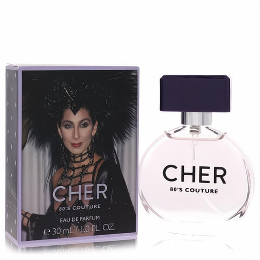 Cher Decades 80'S Couture 1 oz EDP. Round glass bottle with dark cap, beside a vibrant lavender box featuring iconic Cher.