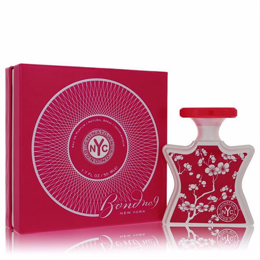 Chinatown by Bond No. 9 1.7 oz EDP. Frosted star bottle with vibrant red cherry blossoms, beside its elegant silver-accented box.