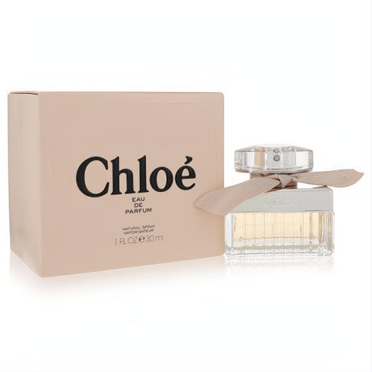 Luxurious Chloe Eau De Parfum 1 oz spray. Elegant ridged glass bottle with a silver cap and signature pink ribbon, beside its blush box.