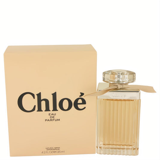 Luxurious Chloe Eau De Parfum 4.2 oz spray. Clear ribbed glass bottle, faceted cap, delicate beige ribbon, and matching box.