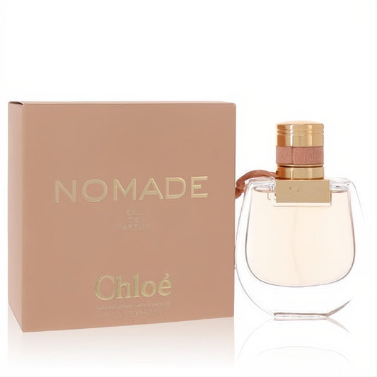 Elegant Chloe Nomade 1.7 oz Eau De Parfum bottle with a chic gold cap and pink ribbon, beside its blush box.