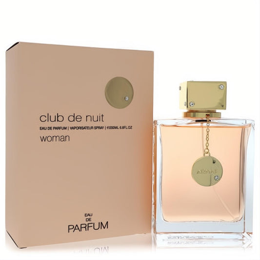Captivating Club De Nuit by Armaf 6.8 oz women's EDP. Clear bottle with gold cap, charm, and peach liquid, next to its chic box.