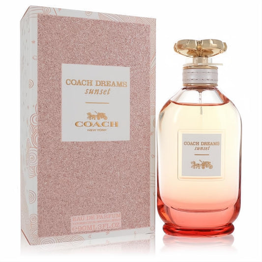 Coach Dreams Sunset 3 oz women's perfume. Vibrant sunset-gradient glass bottle, luxurious gold floral cap, and sparkling rose gold box.