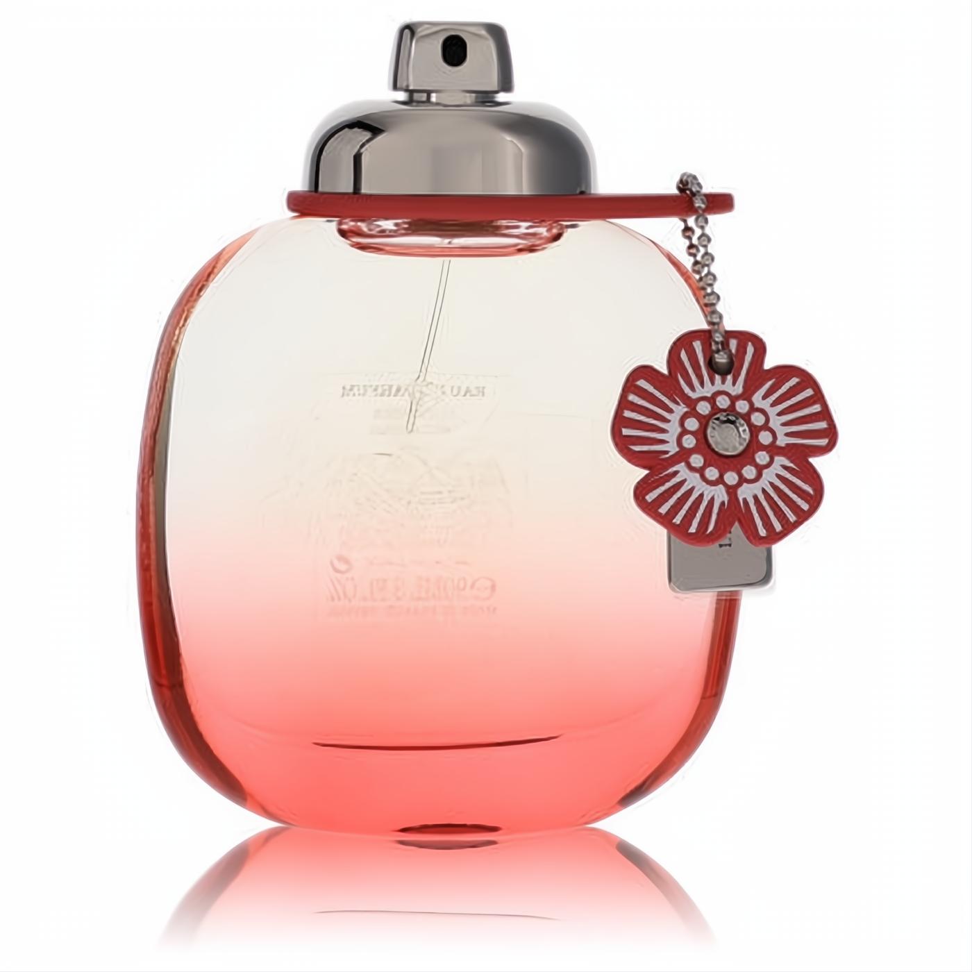 Elegant Coach Floral Blush perfume bottle, clear to vibrant coral gradient glass, with a sleek silver cap and charming red floral accent.