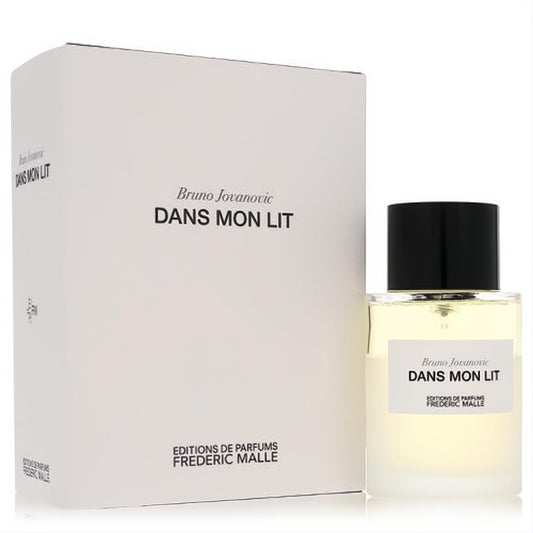 Elegant Dans Mon Lit linen spray by Frederic Malle. Clear glass 3.4 oz bottle with light amber liquid, black cap, and crisp white packaging box.