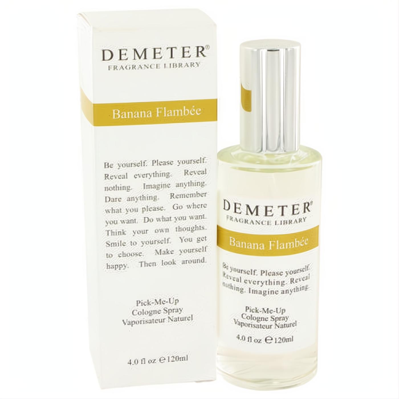 Demeter Banana Flambee 4 oz cologne spray. Clear glass bottle, sleek silver cap, and elegant white box with yellow branding.