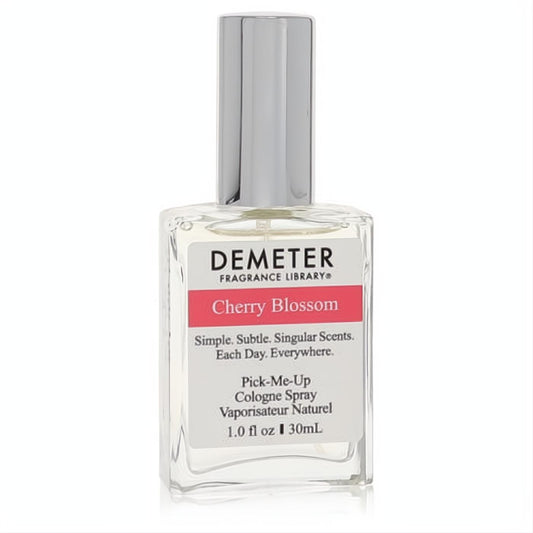 Elegant Demeter Cherry Blossom 1 oz women's cologne spray. Clear glass bottle, sleek silver cap, and a white label with a vibrant pink 'Cherry Blossom' band.