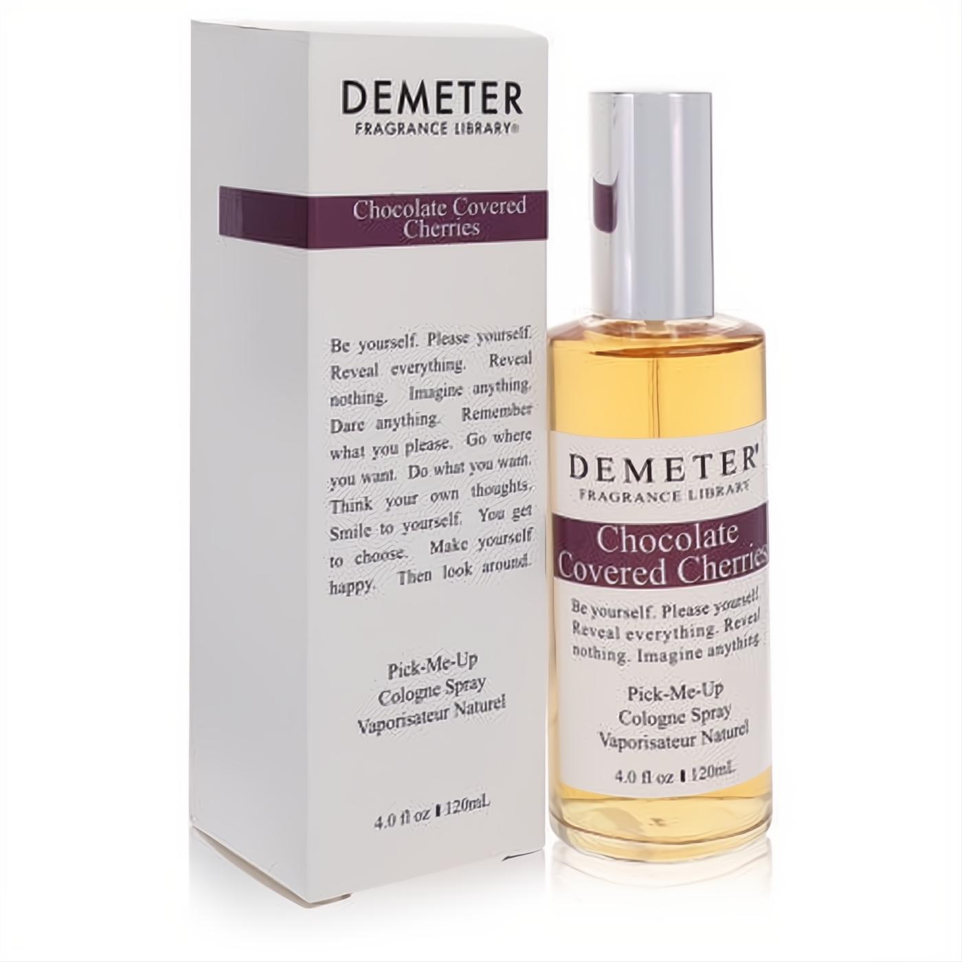 Demeter Chocolate Covered Cherries 4 oz cologne spray. Clear glass bottle with amber liquid, next to its sleek white box with purple accents.