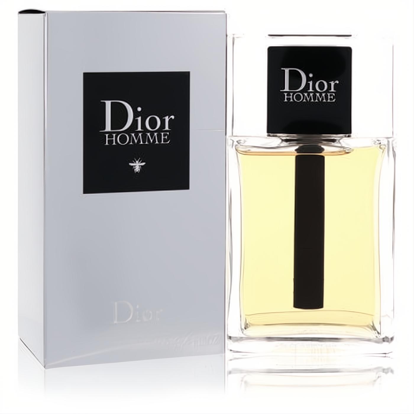Experience Dior Homme men's Eau De Toilette. Sleek clear glass bottle with black cap and golden liquid, beside its elegant silver box.