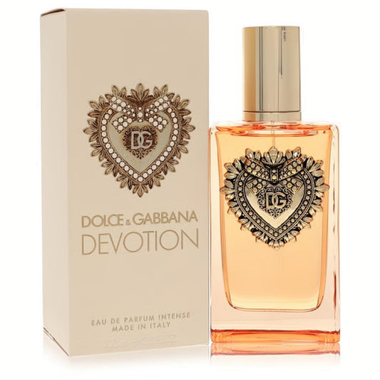 Dolce & Gabbana Devotion Intense EDP. Elegant clear bottle, warm amber liquid, and ornate gold heart with DG logo. Matching beige box.