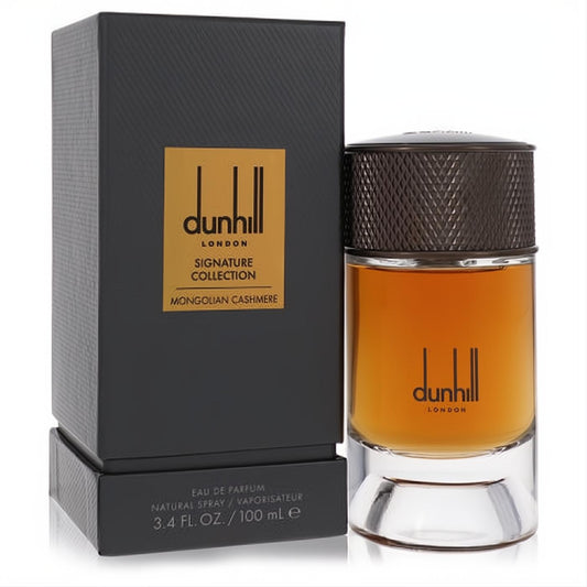 Dunhill Mongolian Cashmere 3.4 oz EDP. Luxurious amber fragrance in a sleek bottle with a dark textured cap, beside its elegant black and gold Signature Collection box.