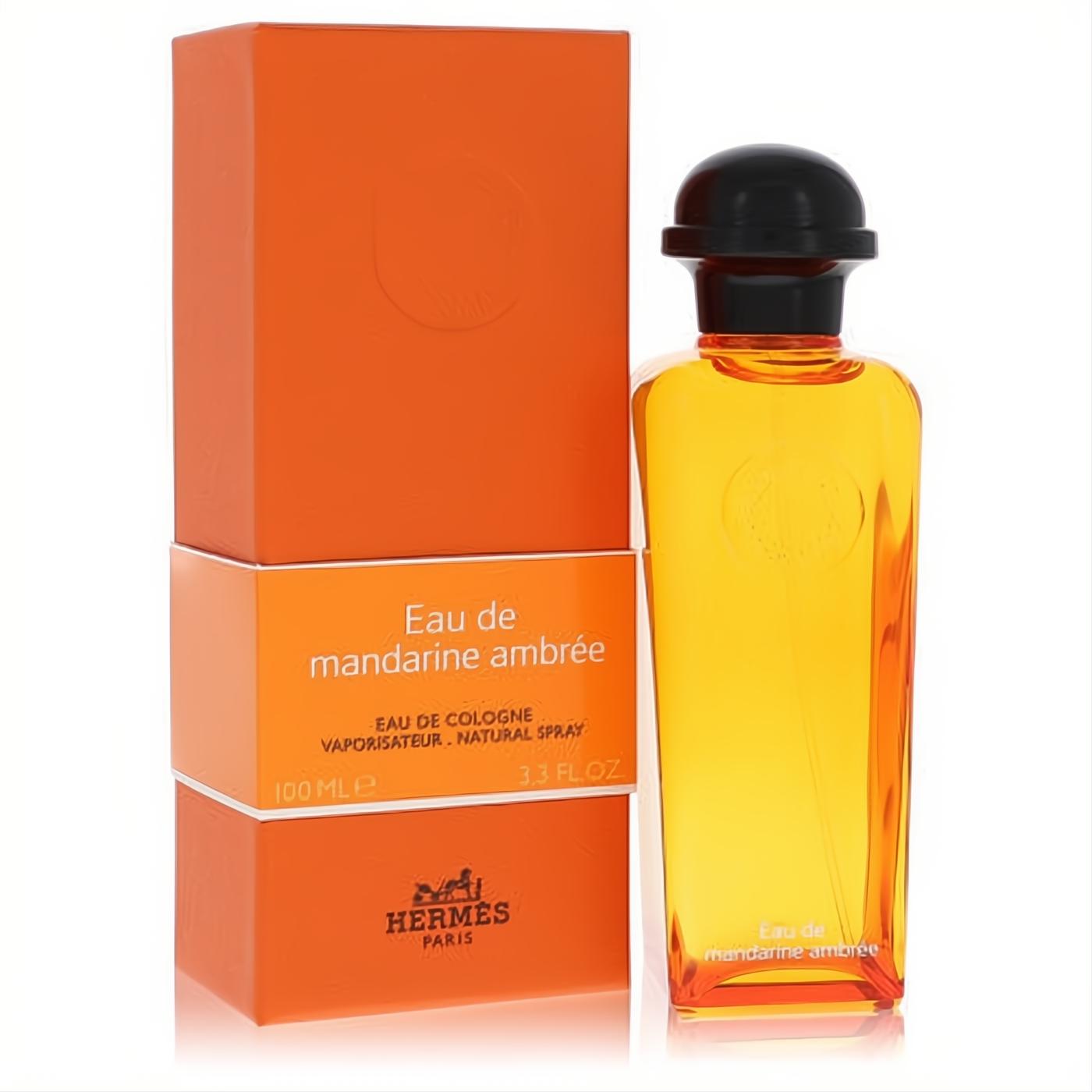 Hermes Eau De Mandarine Ambree 3.3 oz unisex cologne in a radiant amber bottle with black cap, next to its iconic orange box.