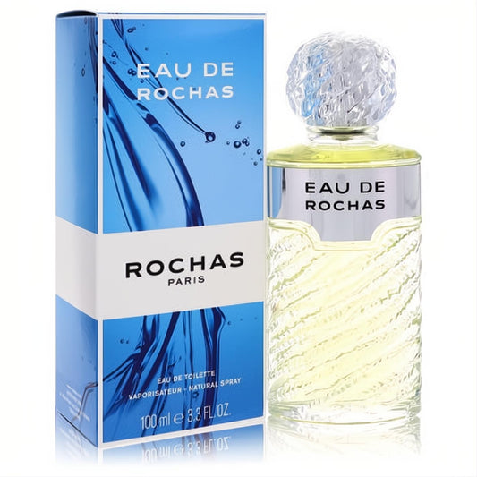 Experience Eau De Rochas 3.4 oz EDT. Elegant textured glass bottle, faceted cap, and vibrant blue water-themed box.