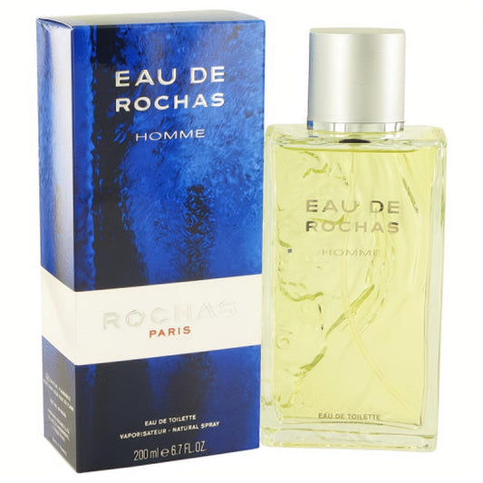 Eau De Rochas Homme 6.7 oz EDT spray. Clear glass bottle with light amber liquid and silver cap, next to its bold blue box.