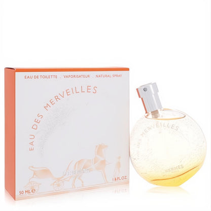 Luxurious Hermes Eau Des Merveilles 1.6 oz EDT spray. Elegant spherical amber glass bottle with white cap and iconic orange box.