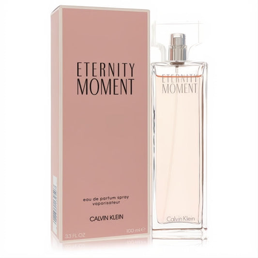 Eternity Moment by Calvin Klein 3.3 FL OZ EDP spray. Sleek clear glass bottle with silver accents, beside its elegant soft pink box.
